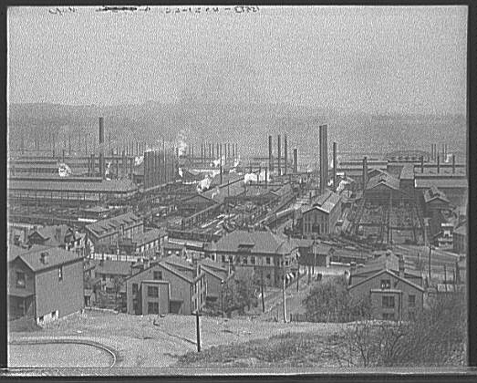 Industrial site with several smokestacks and very dirty air