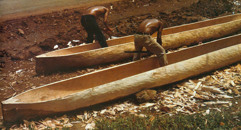 Two shirtless men hollowing out logs