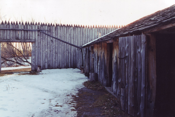 A snowy scene at a log fort with log pickets