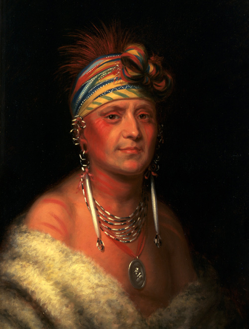 Indian with colorful headband and large peace medal necklace