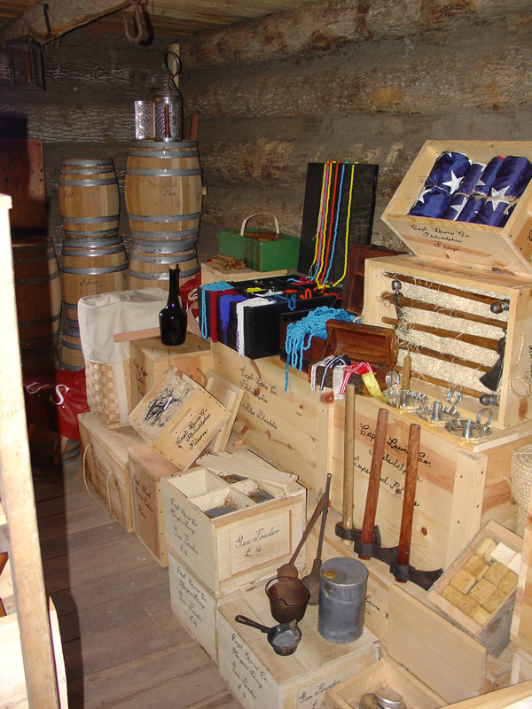 Log cabin storeroom with barrels, crates and beads for Native Americans