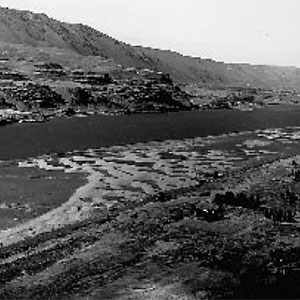 Columbia River with sand dunes on one shore and basalt cliffs on the other