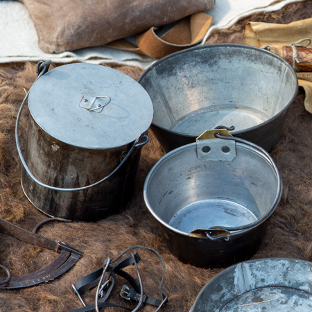 Fire-charred tin and brass kettles