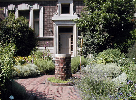 Rush's garden: paved in red brick with numerous plants, shrubs, and trees