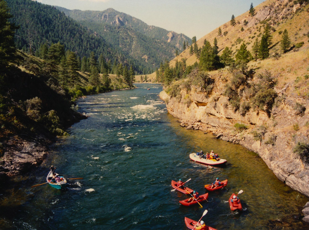 Kayaks, a raft, and a driftboat head down the Salmon River