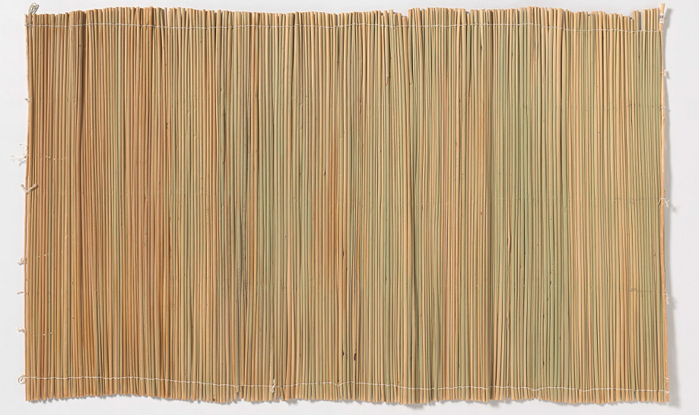 Thin, tan bulrush reeds sewn together to make a mat