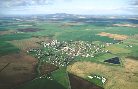 Aerial photo of a prairie with rectangular farm fields and a small town, a campsite on Ordway's fishing trip