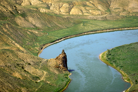 Aerial photo of a tall, pointing rock jutting above the Missouri River